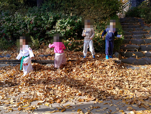 지난 24일 오후 서울 용산구 효창공원. 낙엽에서 아이들이 뛰어놀고 있다. 주변에는 담배 꽁초가 널부려져 있다.