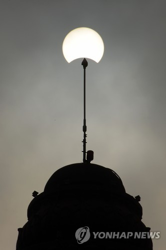 This picture shows the moon passing in front of the sun during a partial solar eclipse in Phnom Penh on March 9, 2016. A total solar eclipse swept across the vast Indonesian archipelago on March 9, witnessed by tens of thousands of sky gazers and marked by parties, Muslim prayers and tribal rituals. Partial eclipses were also visible over other parts of Asia and Australia. / AFP / TANG CHHIN SOTHY