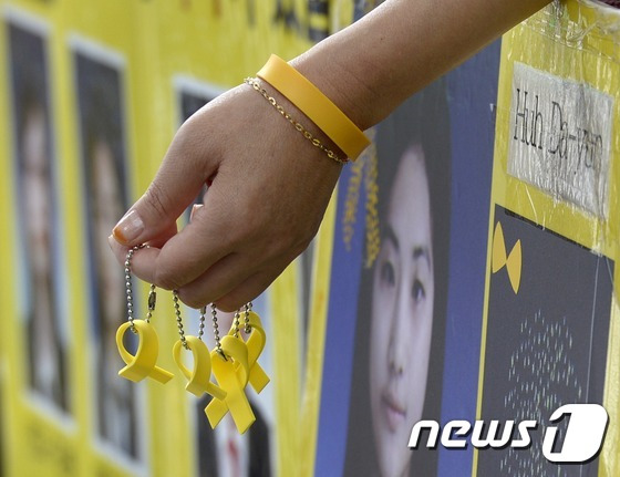 지난 8월 30일 오후 서울 마포구 홍대입구역 8번출구 앞에서 자원봉사자들이 조속하고 온전한 선체인양을 촉구하며 시민들에게 세월호 리본을 나눠주고 있다. 2016.8.30/뉴스1 © News1 안은나 기자