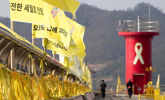 지난 21일 진도 팽목항을 찾은 추모객들이 박 대통령 퇴진 등의 내용을 담은 리본과 깃발 주변을 지나고 있다. [프리랜서 오종찬]