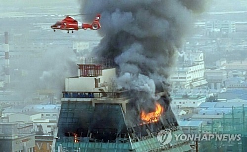 지난 7일 오후 2시 30분께 경남 김해시 어방동 15층짜리 건물 13층에서 불이 나 출동한 소방헬기가 진화작업을 벌이고 있다.