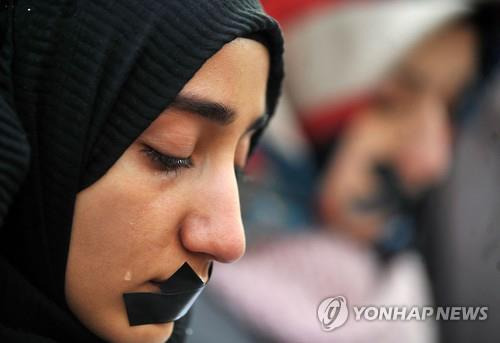 보스니아에서 알레포 주민들에 연대를 표하는 시위에 참가한 여성이 눈물을 흘리고 있다.[AFP=연합뉴스]