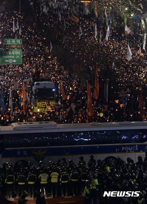 【서울=뉴시스】최진석 기자 = 17일 오후 서울 종로구 안국역 네거리에서 제8차 촛불집회 참가자들이 헌법재판소로 행진을 하다 경찰에 막히자 자리를 잡고 정권퇴진 촉구 시위를 하고 있다. 2016.12.17.   myjs@newsis.com