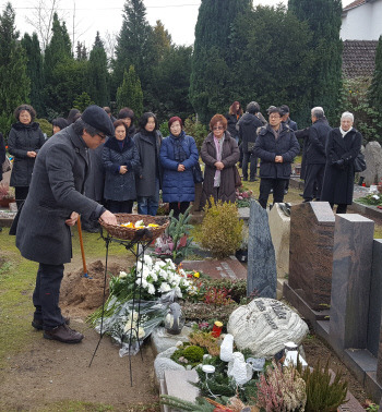 28일(현지시간) 독일 호이젠스탐 시립묘지에서 열린 ‘동백림 사건’ 피해자 강혜순씨의 장례식에서 교민들이 헌화하고있다.