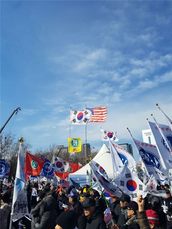 ▲18일 서울시청앞 대한문 앞 태극기 집회를 위해 모인 사람들이 각종 깃발을 흔들고 있다.