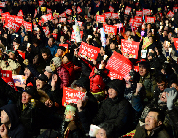 헌법재판소가 박근혜 대통령 파면을 결정한 10일 저녁 시민들이 서울 광화문광장에 모여 ‘박근혜 탄핵 촛불 승리’ 등의 손팻말을 들고 환호하고 있다. 김영민 기자 viola@kyunghyang.com