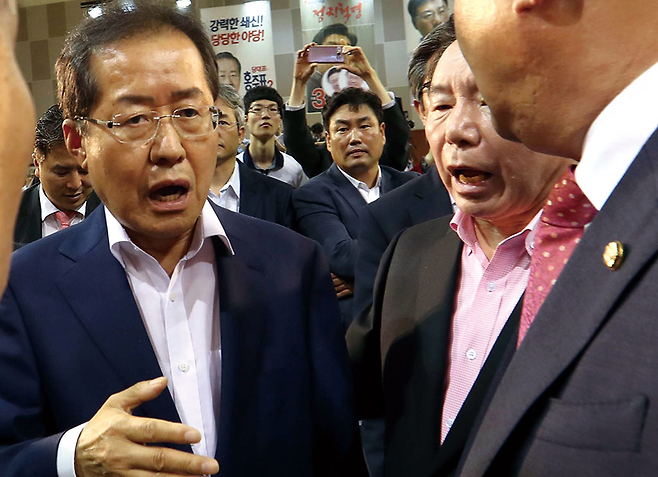 6월26일 대전에서 열린 자유한국당 대표 선출을 위한 전당대회에서 홍준표 후보(사진 왼쪽)가 바른정당 합류를 시도했다는 의혹을 제기한 원유철 후보 발언에 화가 나 행사장을 나가고 있다. ⓒ 사진=연합뉴스