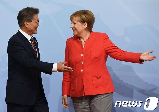 앙겔라 메르켈 독일 총리(오른쪽)가 7일(현지시간) 함부르크 주요 20개국(G20) 정상회담 행사장에 도착한 문재인 대통령에게 자리를 안내하고 있다. © AFP=뉴스1 © News1 최종일 기자