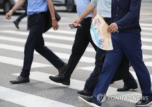 (서울=연합뉴스) 박동주 기자 = 장맛비가 소강상태로 접어들면서 전국 대부분 지역에 폭염주의보가 내리는 등 불볕더위가 기승을 부린 12일 오전 서울 여의도에서 부채를 든 한 시민이 횡단보도를 건너고 있다. 2017.7.12      pdj6635@yna.co.kr