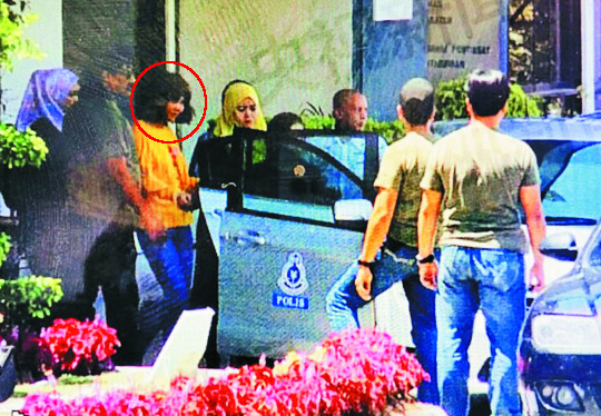 김정남 암살과 관련해 16일 말레이시아 경찰에 체포된 용의자(붉은 원안)가 세팡경찰서에서 수갑을 찬 채 경찰차에 오르고 있다. 이 여성은 인도네시아 여권을 갖고 있었다.  중국 CCTV