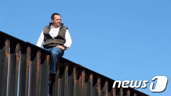 트럼프 대통령의 국경 장벽 설치 공약에 항의하기 위해 9m 높이의 장벽에 올라 항의 퍼포먼스를 벌인 멕시코 의원[출처=트위터]© News1