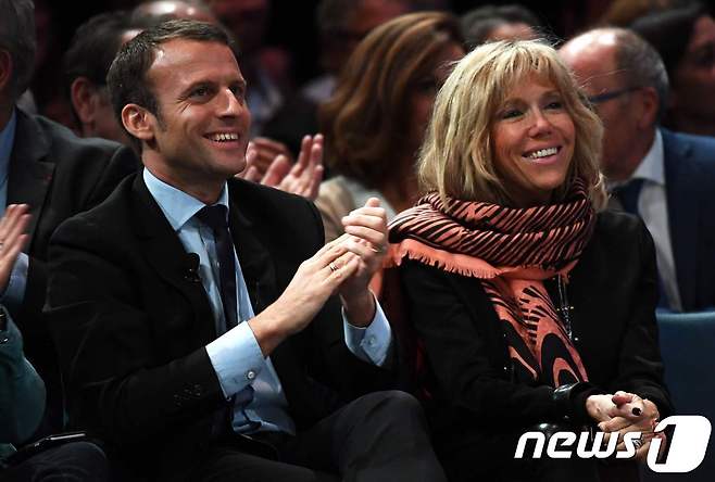 프랑스 대선 1차 투표에서 최다 득표로 결선에 진출하게 된 중도정당 앙마르슈(전진)의 에마뉘엘 마크롱 후보(왼쪽)와 아내인 브리지트 © AFP=뉴스1