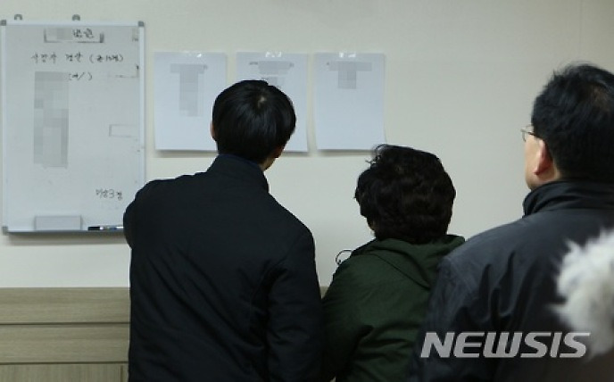 사망자 명단 확인하는 유족들
