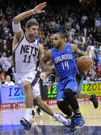 Orlando Magic Guard Jameer Nelson, Right, Drives To The Basket As He Is Guarded By New Jersey Nets Center Brook Lopez