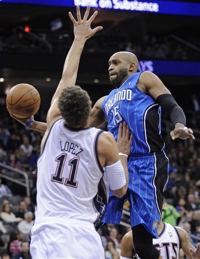 Orlando Magic Forward Vince Carter, Right, Goes Up With The Ball As He Is Guarded By New Jersey Nets Center Brook Lopez
