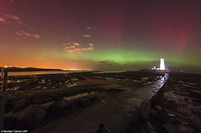 Lit up: The lighthouse appears to light up as a collision of particles from the sun enter the earth's atmosphere
