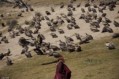 A Tibetan Buddhist monk protects himself from the smell of decomposing bodies near the Larung valley, which is located some 3700 and 4000 metres above the sea level