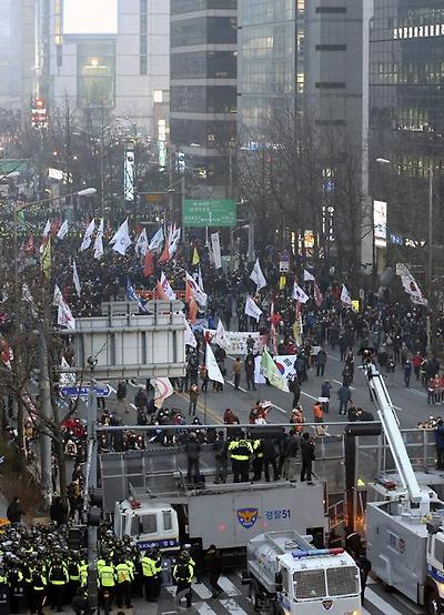 25일 오후 서울 중구 서울광장에서 열린 ‘국민 총파업’ 집회를 마친 참가자들이 시내 도로를 점거하며 행진하자 경찰이 저지하고 있다. 이날 서울광장에는 시위대 1만3000여명이 몰렸고, 주변에 1만5000여명의 경찰까지 배치돼 이 일대가 큰 혼잡을 빚었다