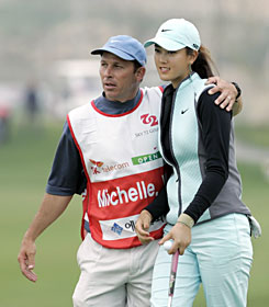 Michelle Wie and her caddie Greg Johnston finish the second round of the SK Telecom Open in Incheon, west of Seoul. Wie shot 3-under 69 and made her first cut in a men's pro event.