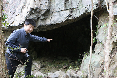 진도군 임회면 상만리의 어귀산 중턱에 있는 호랑이굴에 대해 김동진 서울대 교수가 설명하고 있다.