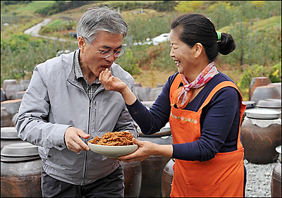  충북 음성 수정산농원을 방문한 문재인 후보가 농원 주인인 남궁영자씨가 건넨 된장을 받아 먹고 있다. 이날 취재진의 요구에 제법 큰 된장을 4번 받아 먹었다. '짜지 않은 가요'라는 질문에 문 후보는 '짠데 맛있네요'라고 답했다.