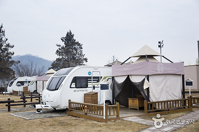 4인이 이용할 수 있는 스탠더드 카라반. 카라반 옆에 데크와 테이블이 있어 바비큐나 모닥불을 피우기 좋다.