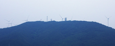  맞은편 먼 산 위에 풍력발전기 풍차날개가 보인다.