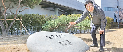 통영문화재단 이용민 본부장이 윤이상 유해가 안장된 너럭바위를 가르키며 안장배경을 설명하고 있다.