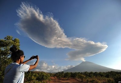 인도네시아의 휴양섬인 발리에서 관광객이 아궁 화산이 연기 기둥을 뿜어내는 모습을 사진으로 담고 있다.
