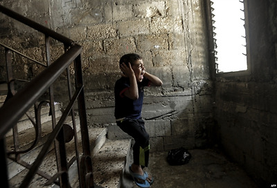 팔레스타인 가자지구 가자시티에서 어린 소년이 창문너머로 보이는 형의 장례식 행렬을 보며 울고 있다. 지난 5월 이스라엘-팔레스타인 충돌 중&nbsp;어린소년의 형이 이스라엘 군이 쏜 총에 맞아 숨졌다.