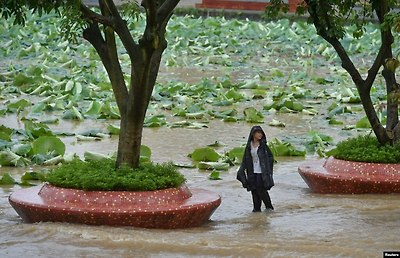 폭우가 내린 중국 쓰촨성 청두에서 소년이 침수된 도로 위에 서 있다.&nbsp;