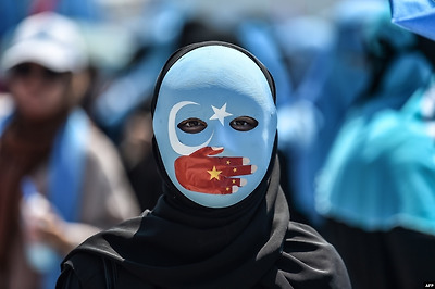 터키 이스탄불에 위치한 중국 영사관 앞에서 중국의 동투르키스탄(위구르족)에 대한 억압을 보여주는 그림을 얼굴에 그린 여성이 중국 정부에 항의하는 시위에 참석하고 있다.