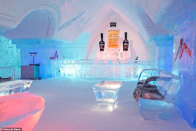 Sculptors use around 2,300 blocks of ice to make furniture, sculptures and ice glasses for Hôtel de Glace. Pictured is its amazing bar
