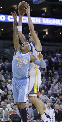 Golden State Warriors Center Andris Biedrins (15) Shoot Over Denver Nuggets Small Forward Carmelo Anthony (15) In The