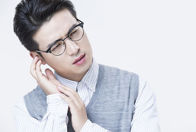 한 남성이 귀를 잡고 통증을 호소하고 있다