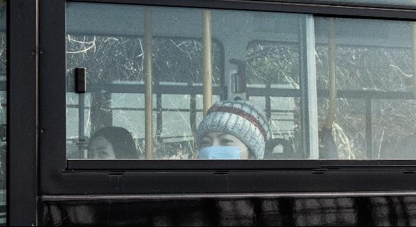 버스 안에 마스크를 쓴 시민이 앉아 있다.