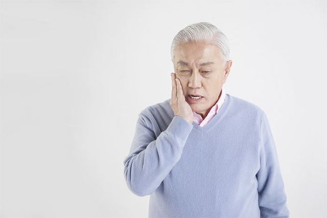 치통을 호소하고 있는 남성 노인의 모습이다