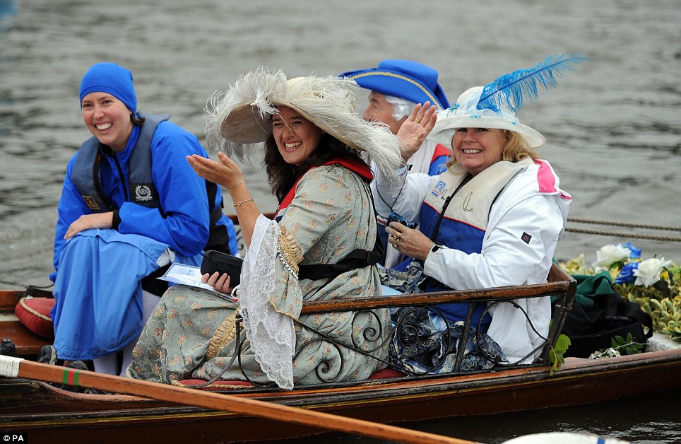 A group of women on one of the rowing boats smile as they get ready