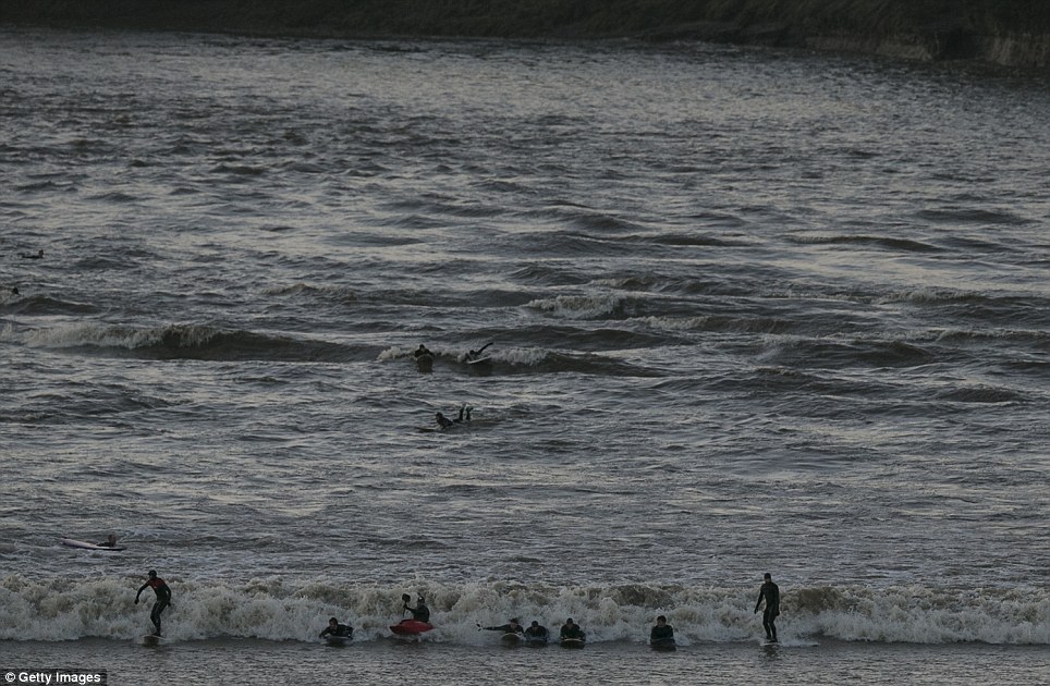 Surfers attempt to ride on a rare maximum five star Severn Bore viewed from Newnham overlooking the River Severn