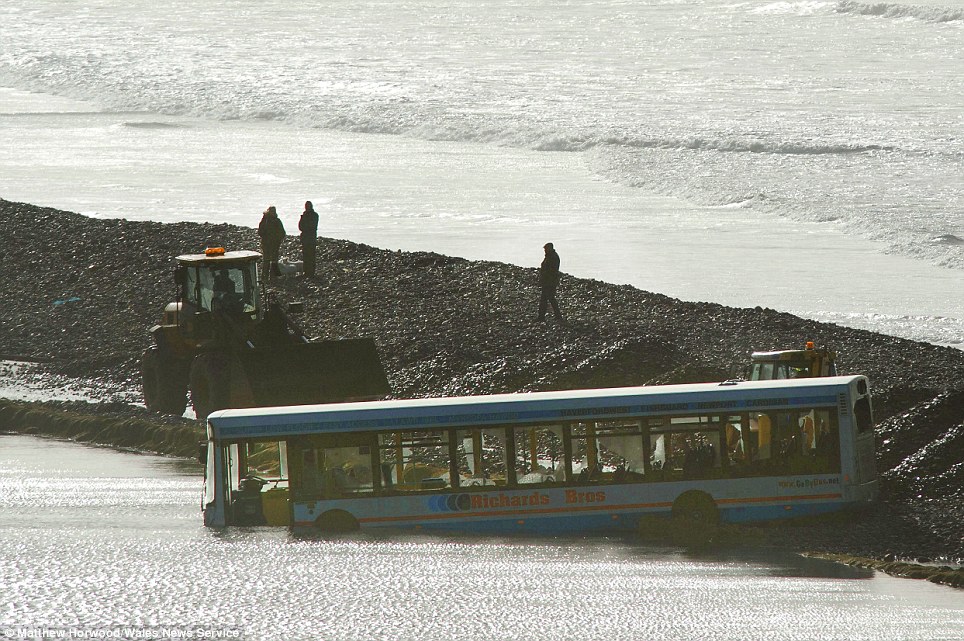 Wider view: A bus is submerged in water after heavy rain and severe flooding in Newgale, West Wales