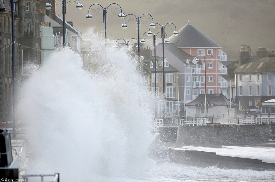 Deserted seafront: Another view of waves crashing up against the sea defences at Aberystwyth during high tide in Wales