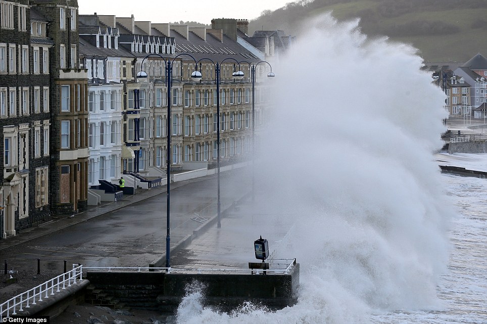 Hitting hard: Waves crash up against the sea defences at Aberystwyth during high tide and high winds