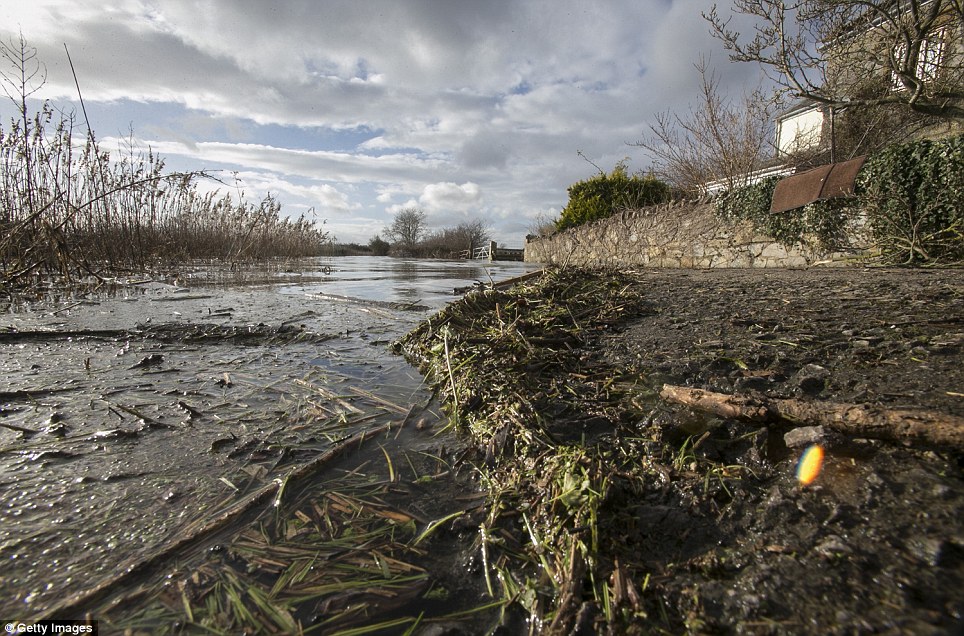 Flood water and debris is seen in front of a house near Muchelney, near Langport in Somerset