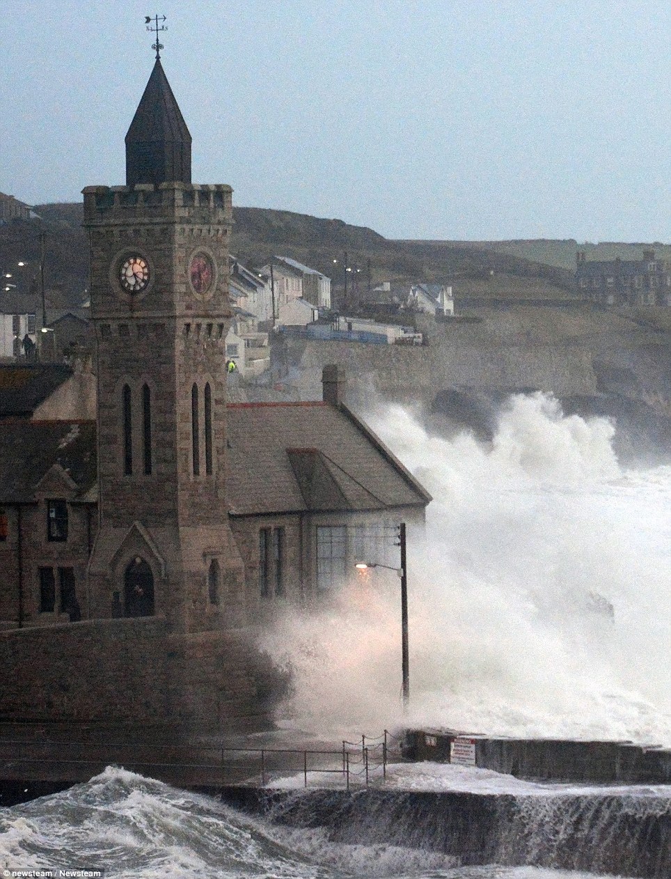 Splash: Waves break over the iconic clock tower in Porthleven on the south coast of Cornwall