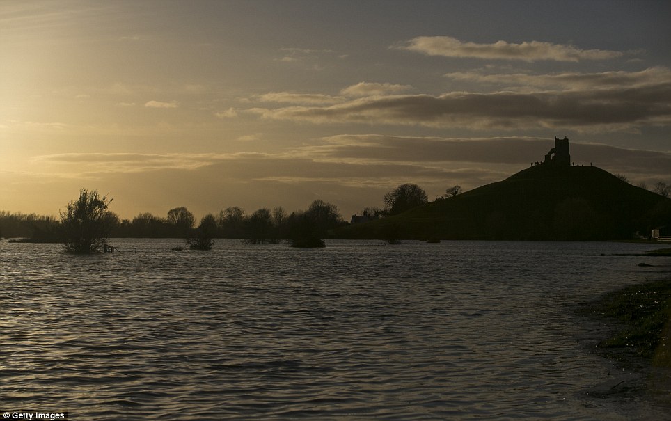 More bad weather on the way: The sun sets over flooded fields surrounding Burrow Mump on the Somerset Levels at Burrow Bridge