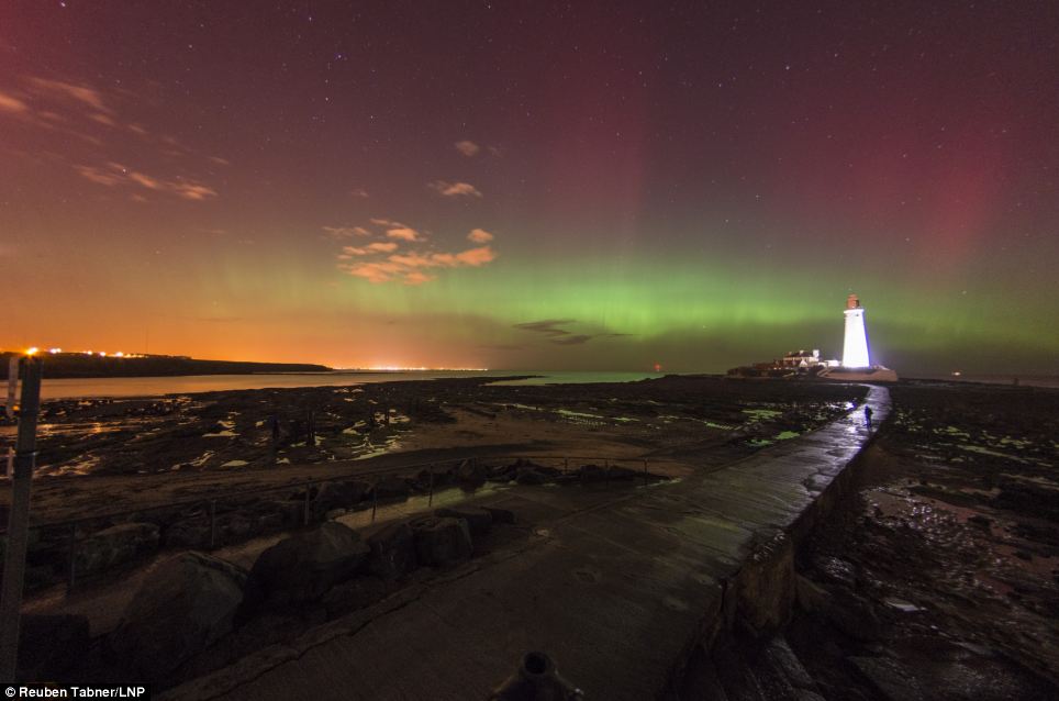 Lit up: The lighthouse appears to light up as a collision of particles from the sun enter the earth's atmosphere
