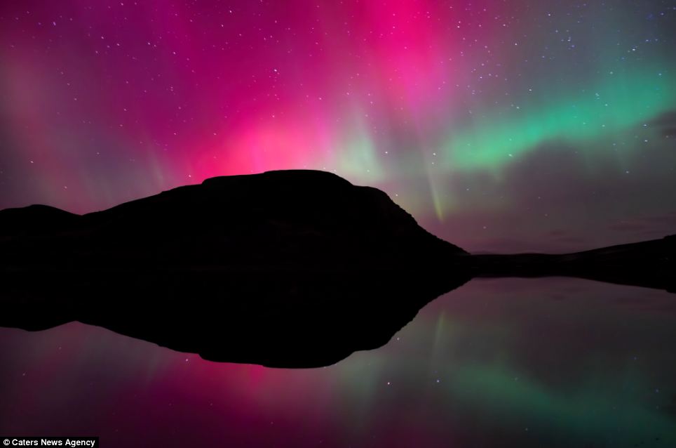 Captivating: Skies over Loch Brora in the Scottish Highlands turn red and green by a mesmerising display of the Aurora Borealis