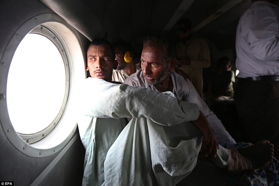 Saved: Pakistani Army soldiers evacuate flood victims through helicopters in Jhang, Punjab province. The waters could spread downriver to affect 5 million people