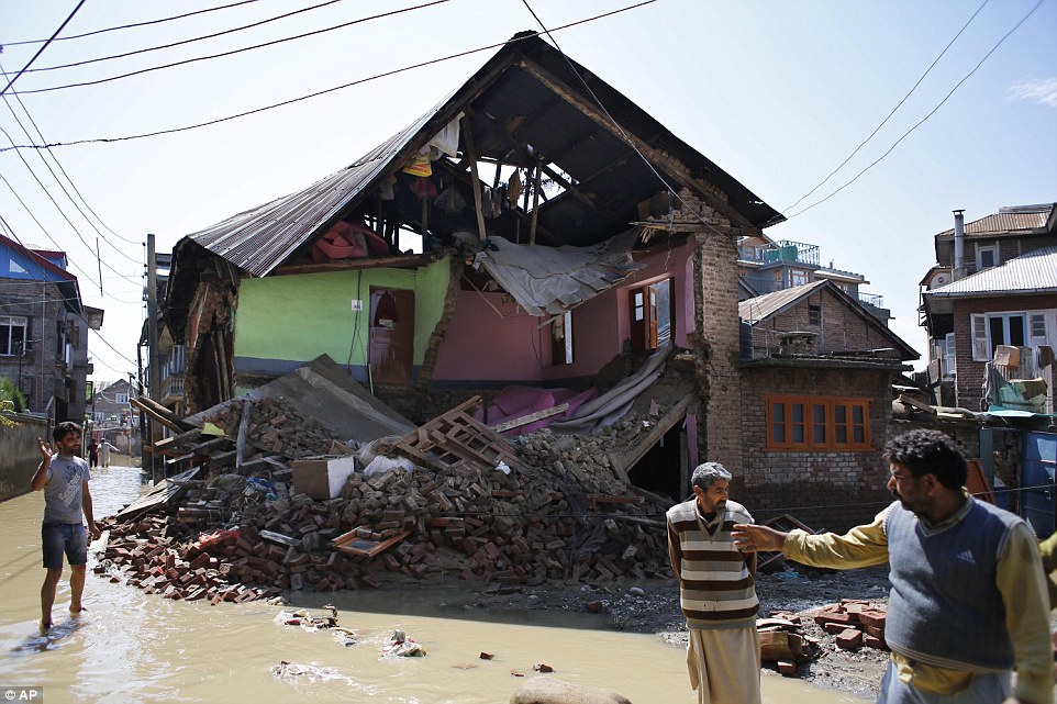 Ruined: Homes in Srinagar have been sliced apart by the waters and the landslides which followed, killing hundreds of people. The survivors will face a bill of millions