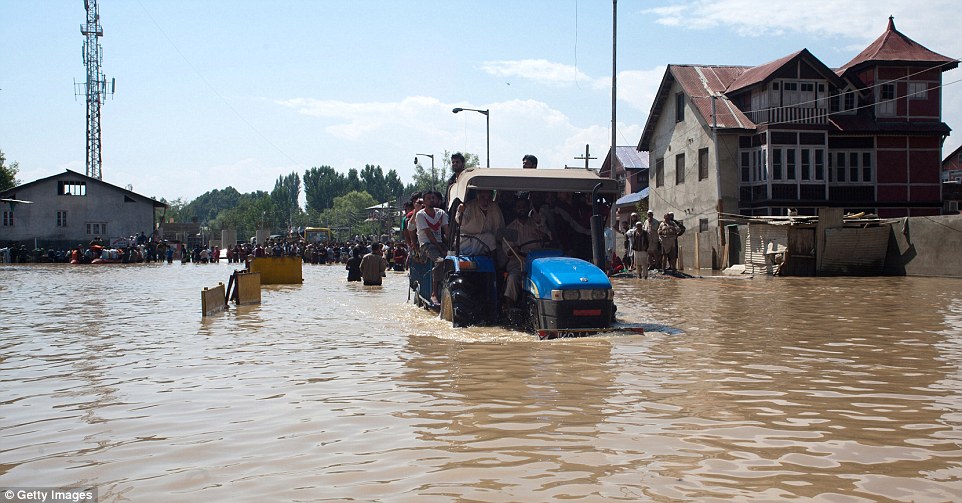 Any means necessary: Residents of the summer capital Srinagar rode to relative safety on the back of a tractor, one of the few vehicles which could brave the flood